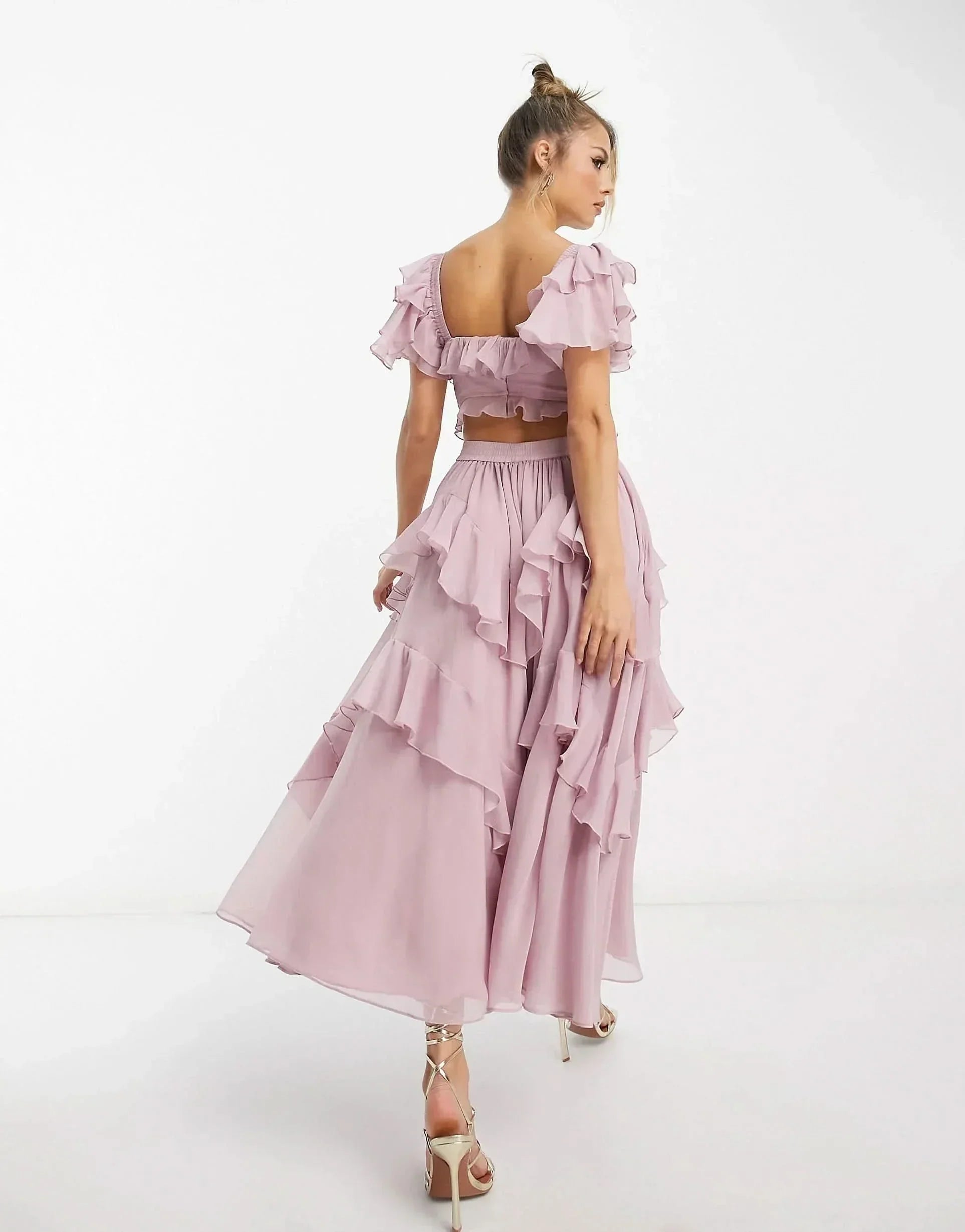 Back view of pink ruffle midi dress showing open back and cascading ruffles