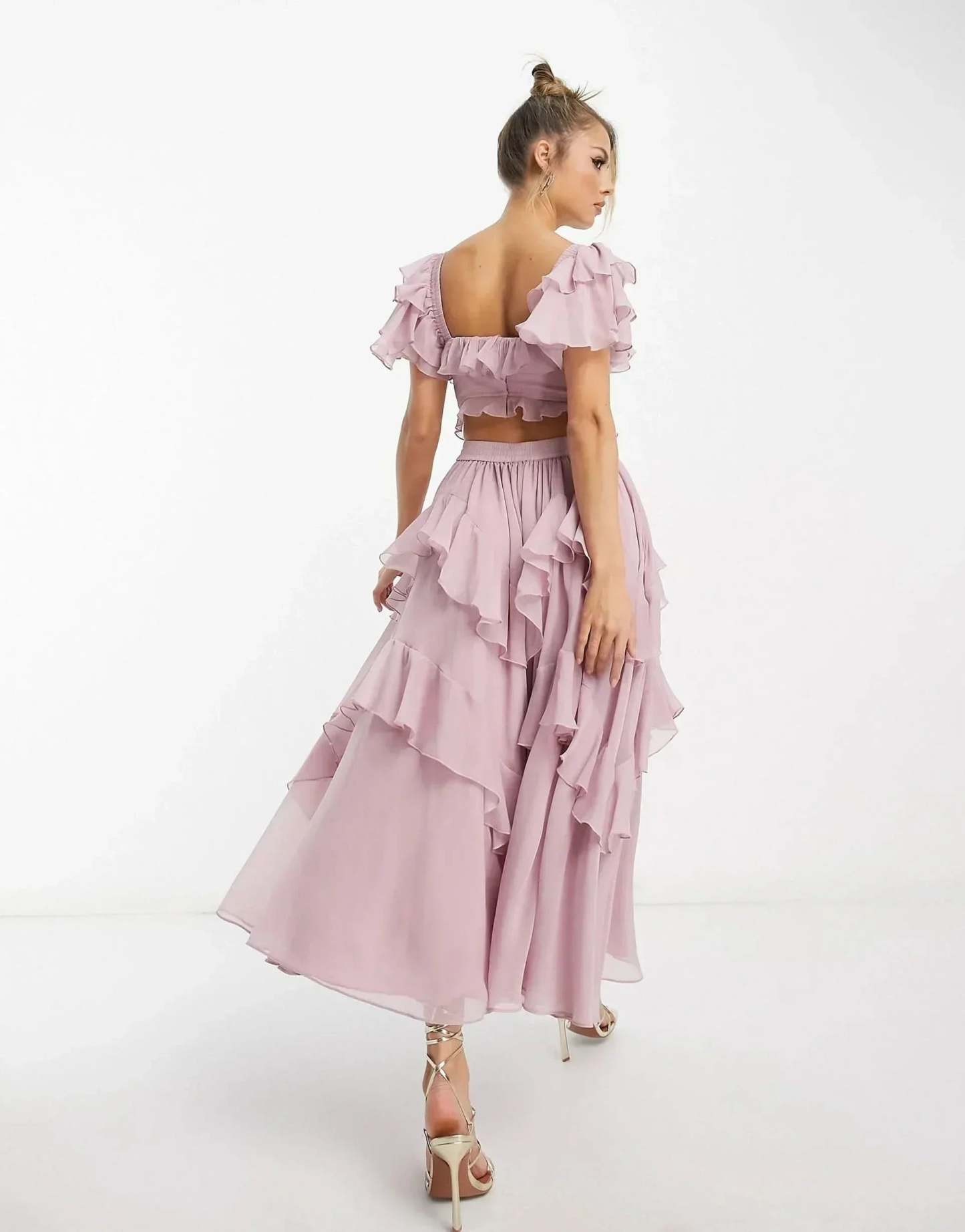 Back view of pink ruffle midi dress showing open back and cascading ruffles