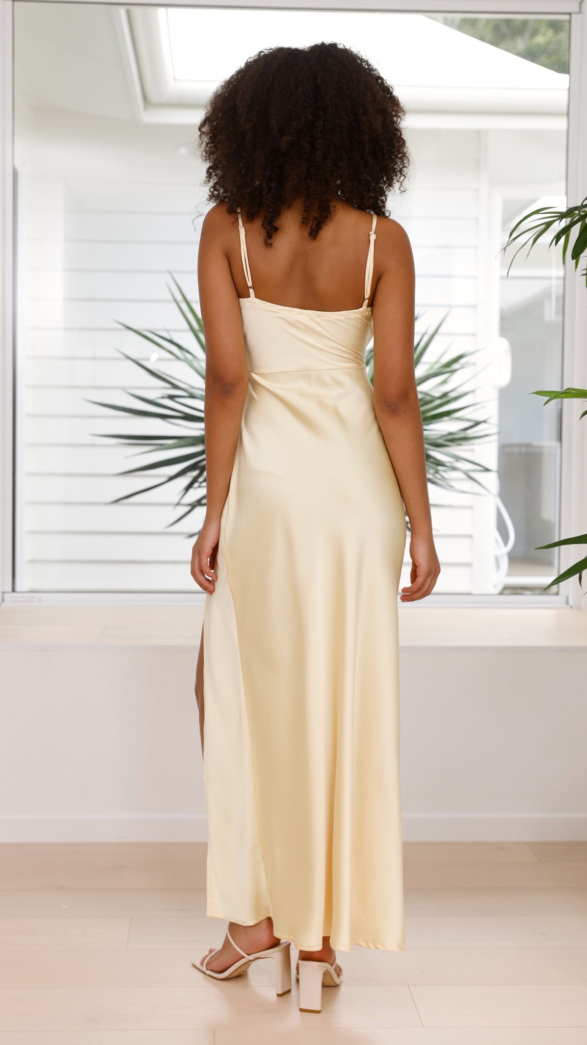 Back view of cream ruched maxi dress showing thin straps