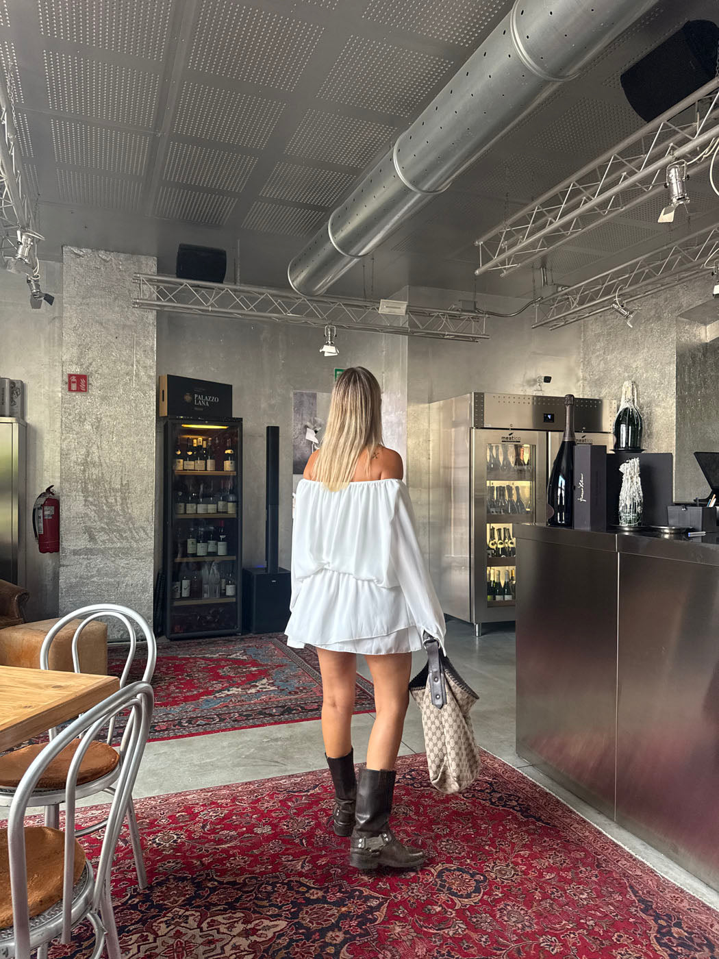 Back view of white ruffle mini dress showing gathered waist and tiered hem