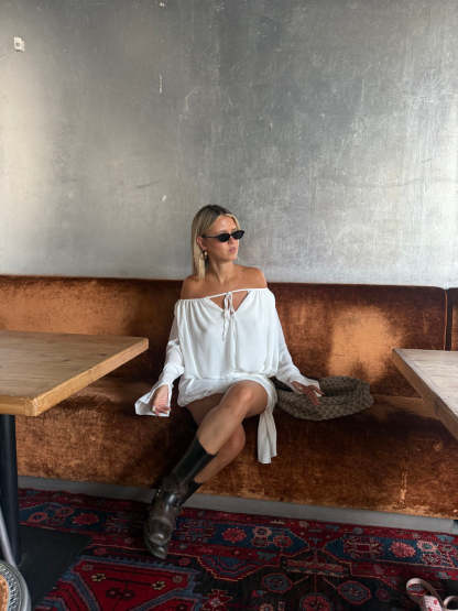 White ruffle mini dress with long sleeves, keyhole neckline, and gathered silhouette