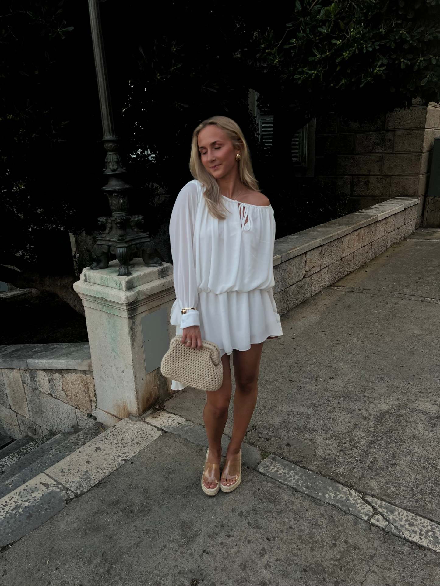 White off-shoulder ruffle mini dress with long puffed sleeves and tie detail