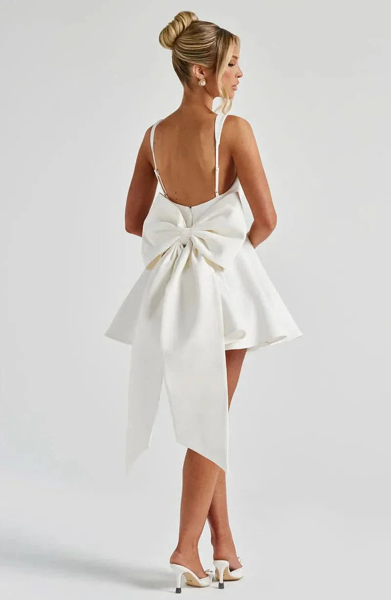 Cream mini dress back view with large bow detail and asymmetrical tail