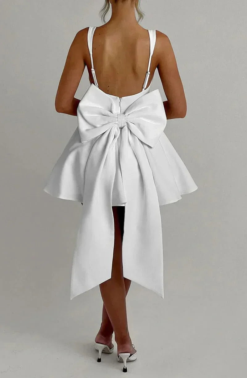 Cream mini dress back view showing structured bow and open back design