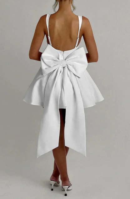 Cream mini dress back view showing structured bow and open back design