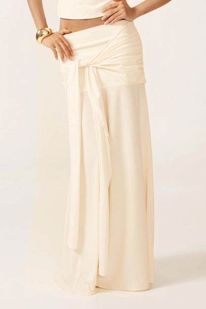 Close-up of cream ruched skirt with tie-front detail and flowing maxi length