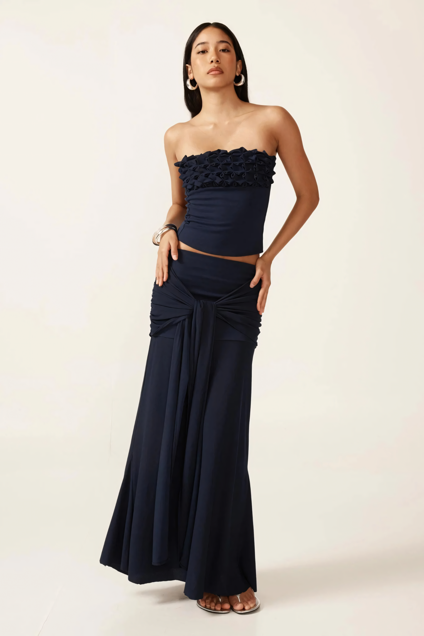 Navy strapless ruched crop top with textured ruffle neckline and matching maxi skirt with tie waist