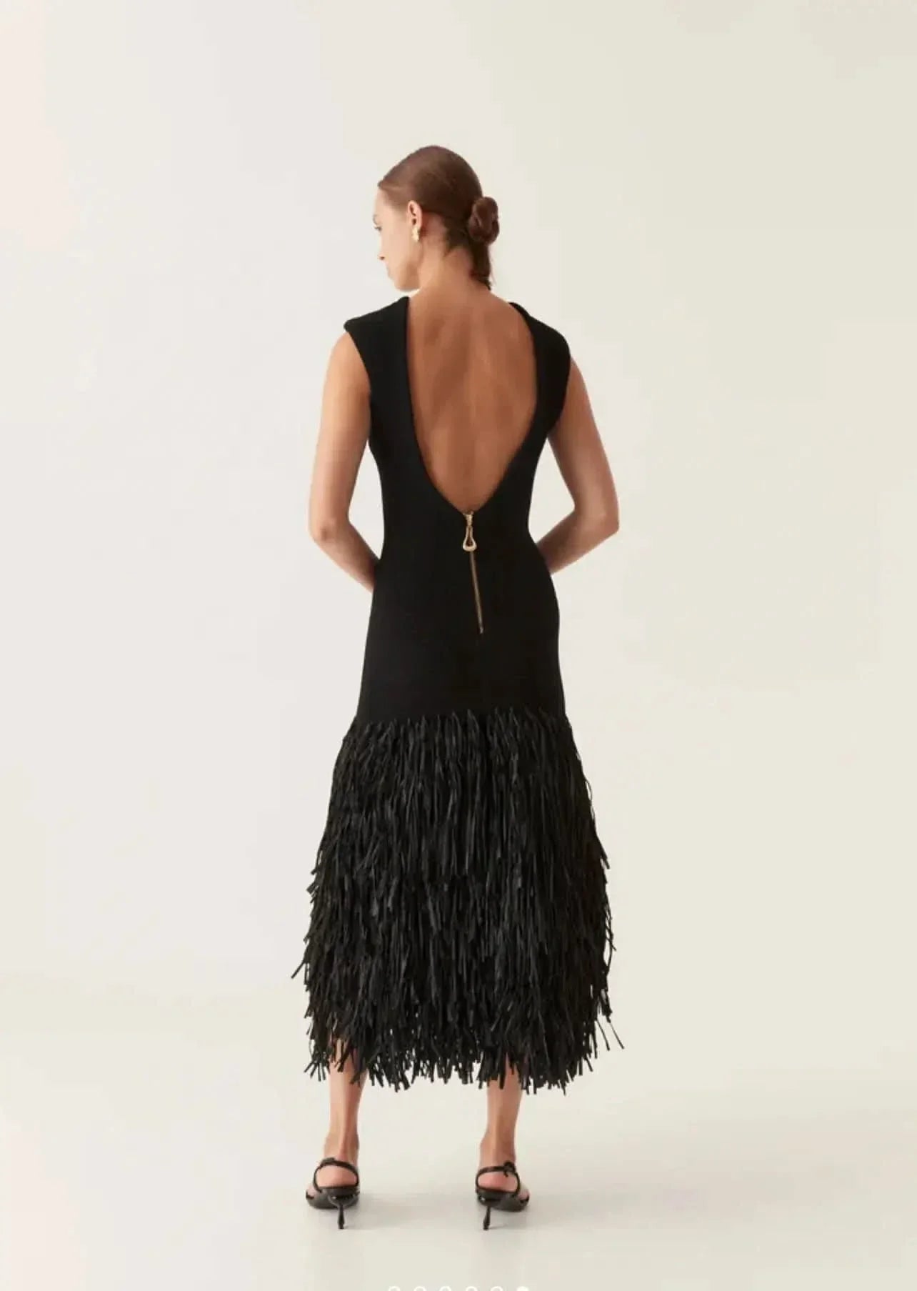 Back view of black midi dress with deep V-back and gold zipper detail