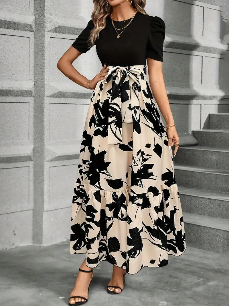 Fitted black top with adjustable tie waist and flowing floral maxi skirt detail
