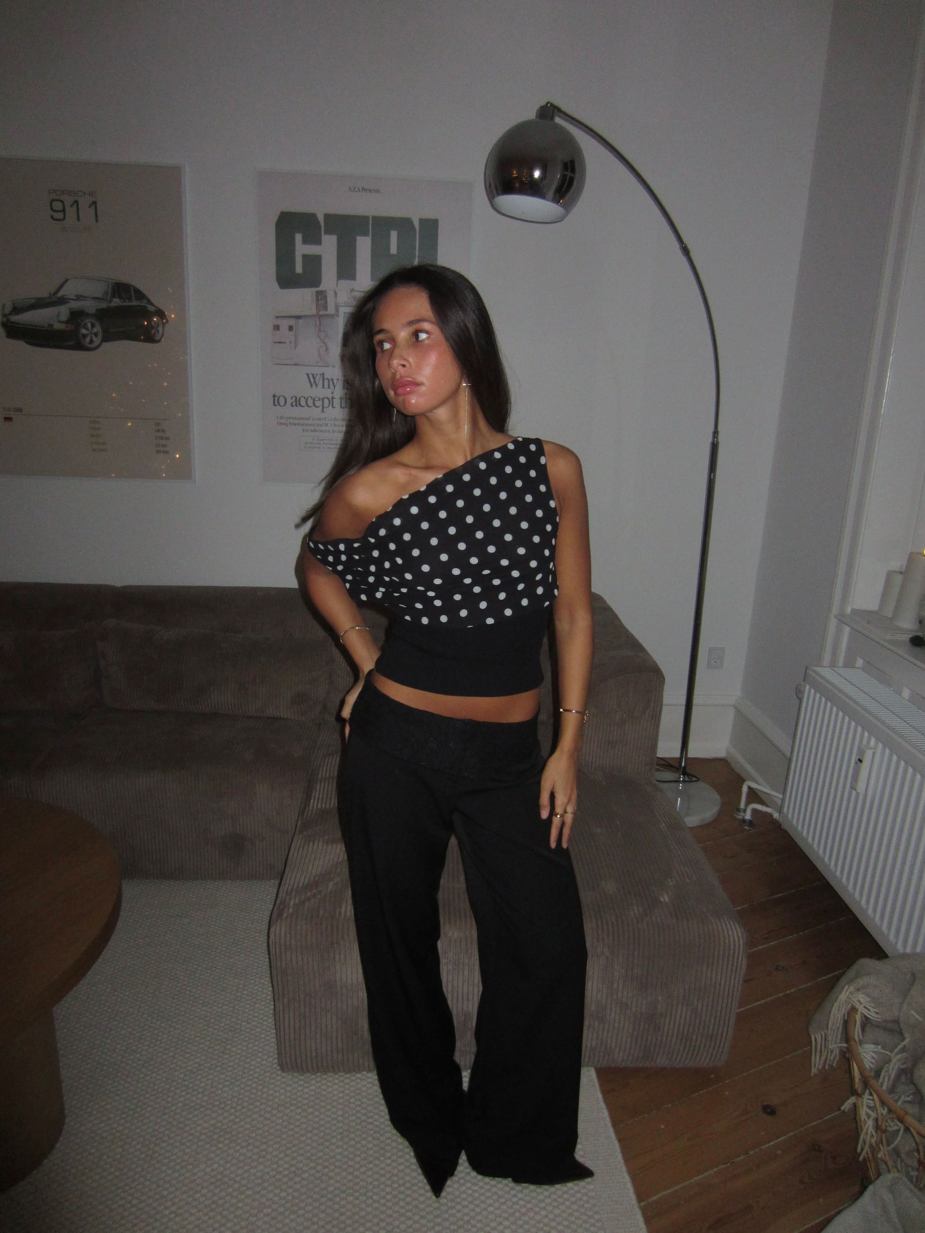 One-shoulder black polka dot crop top with asymmetrical neckline