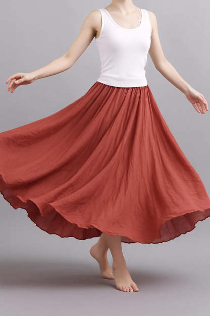 Terracotta pleated maxi skirt in motion showing graceful drape and movement