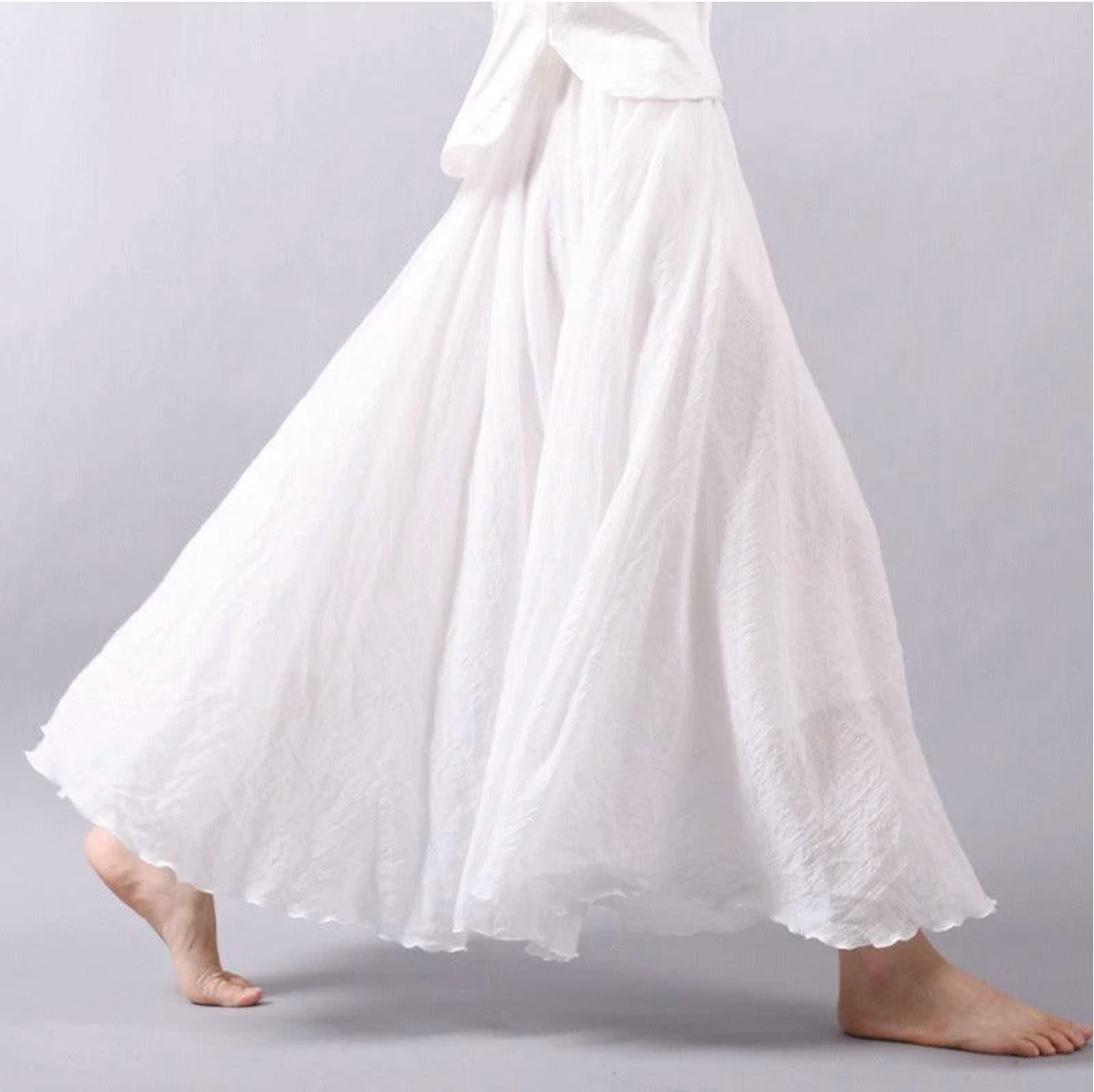 White pleated maxi skirt side view with full skirt movement