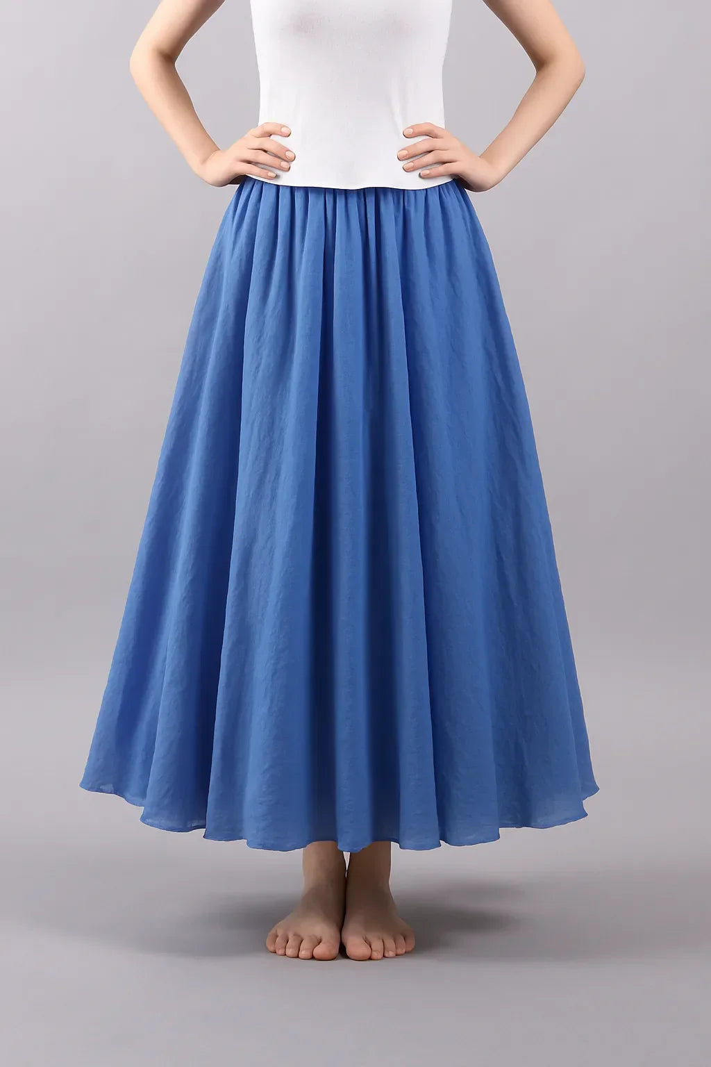 Blue pleated maxi skirt front view with structured waist detail