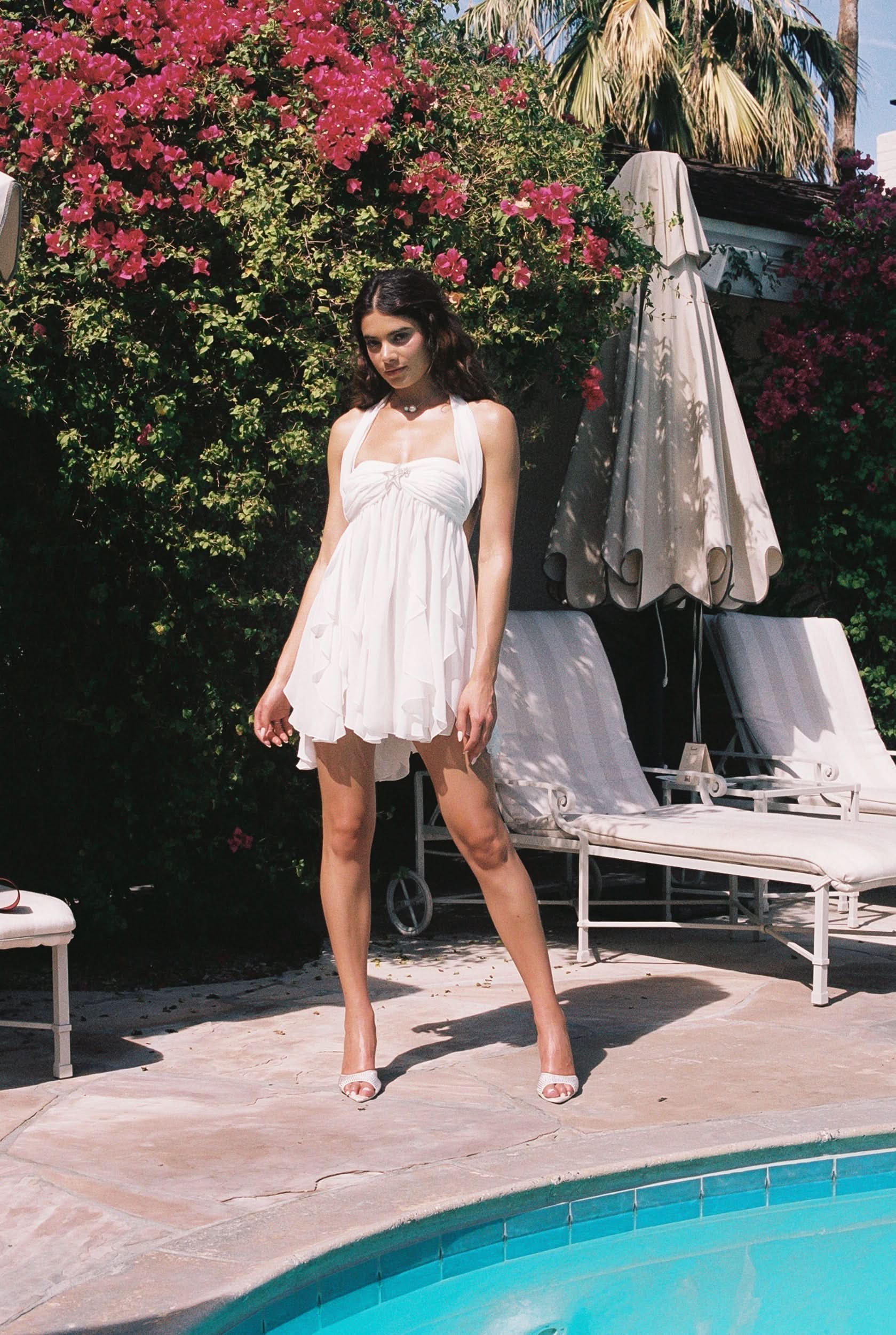 White ruffled mini dress with halter neckline and layered flowing skirt