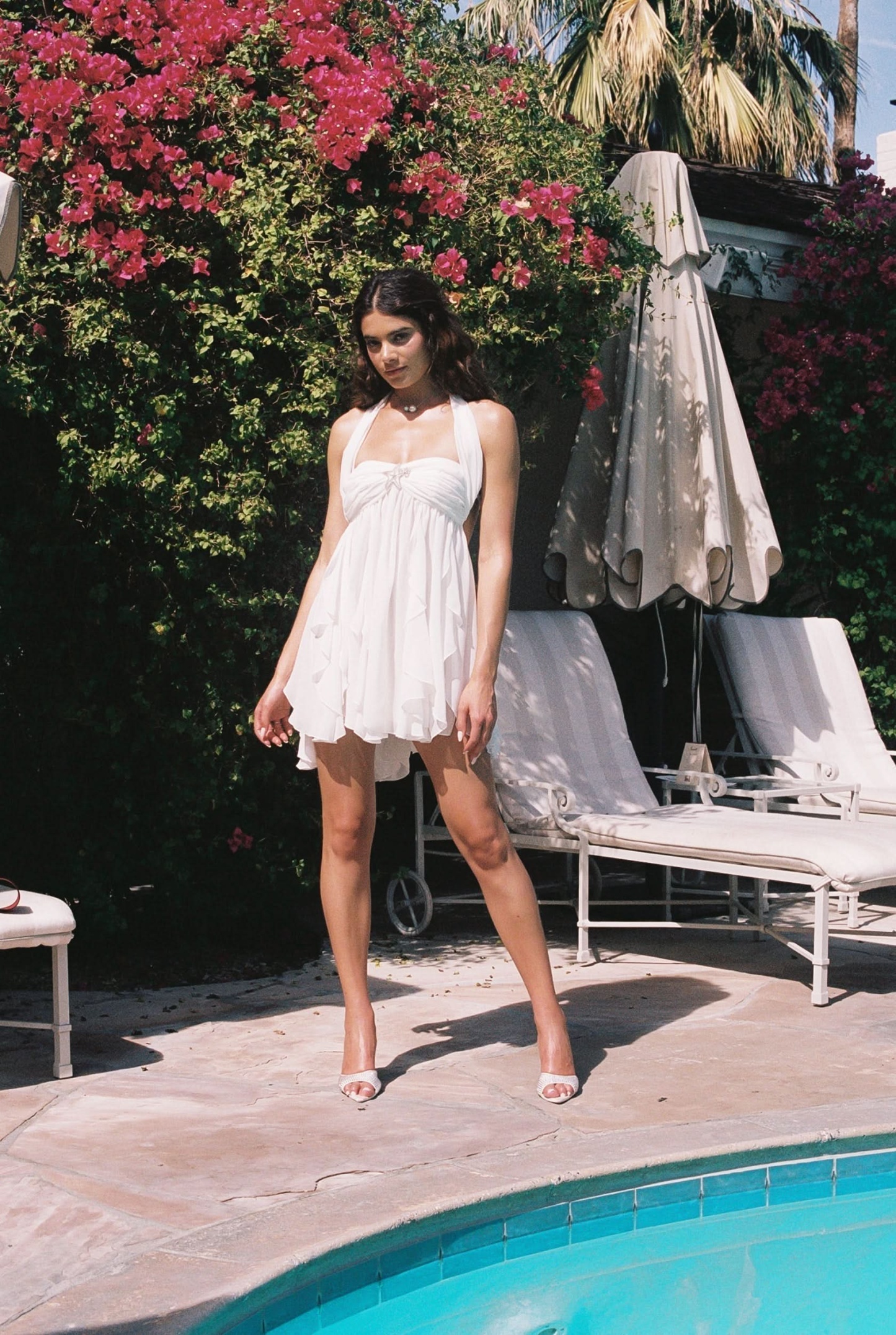 White ruffled mini dress with halter neckline and layered flowing skirt