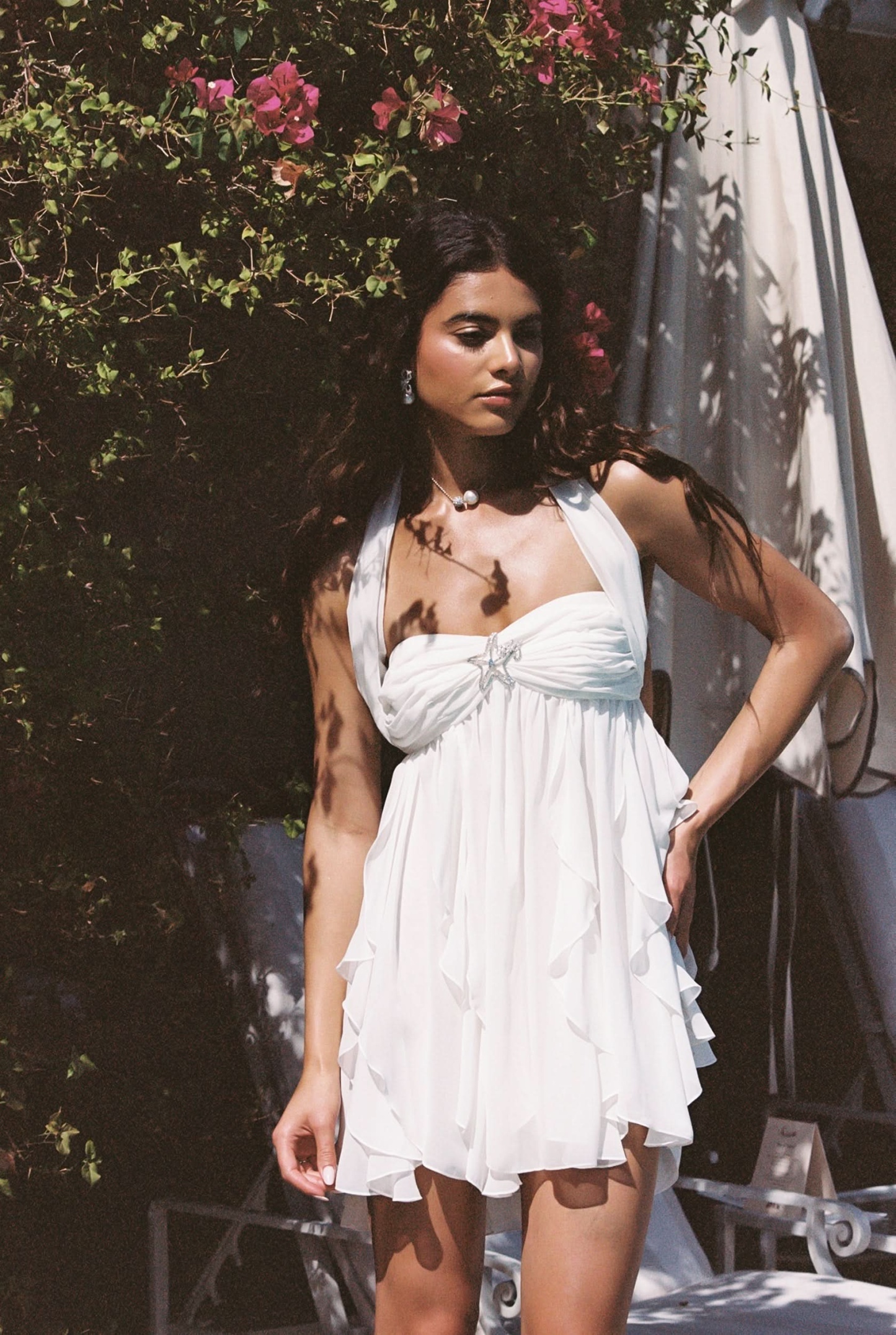 Cream halter mini dress with cascading ruffles and gathered bodice detail