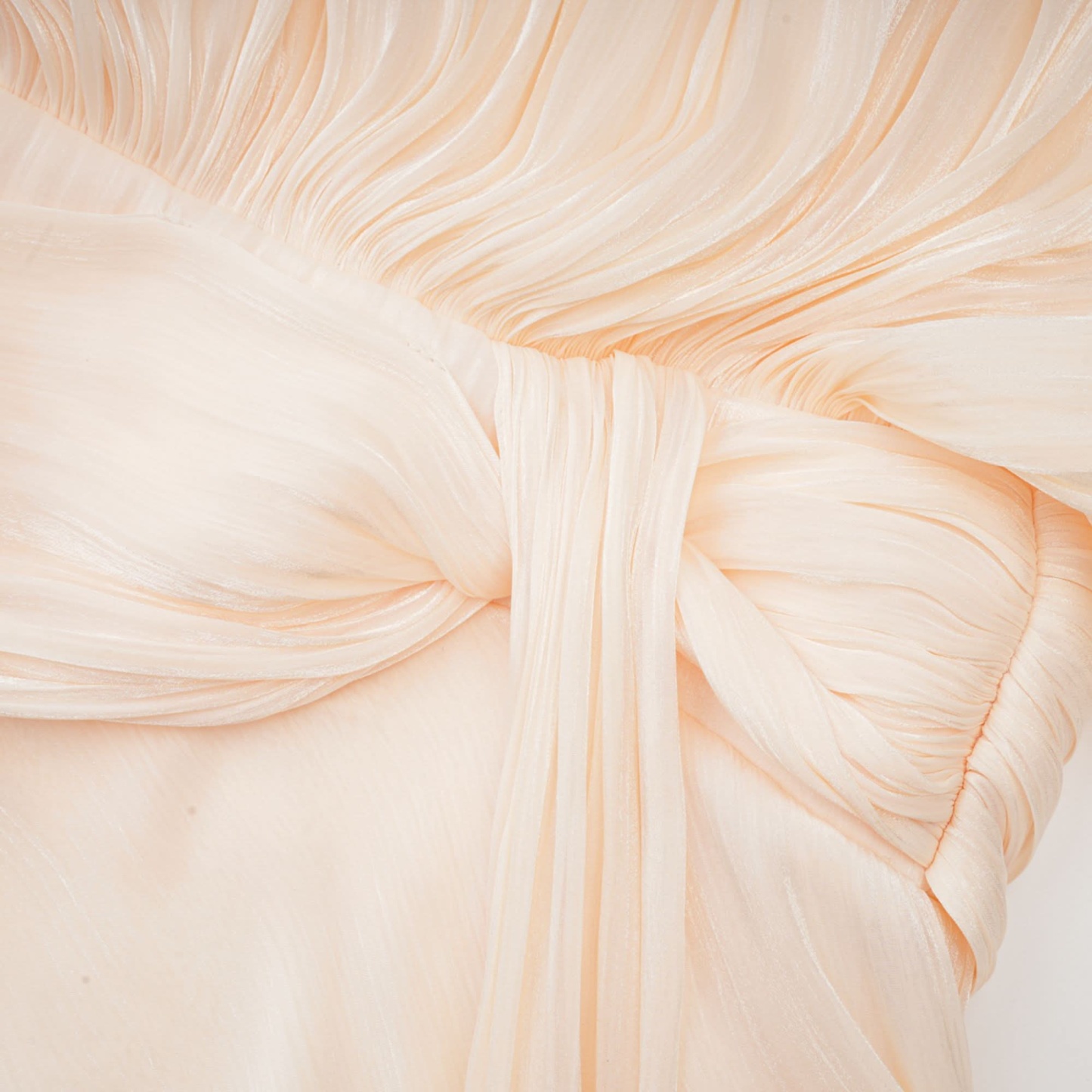 Detailed view of cream ruffle cape with fine pleating and layered texture