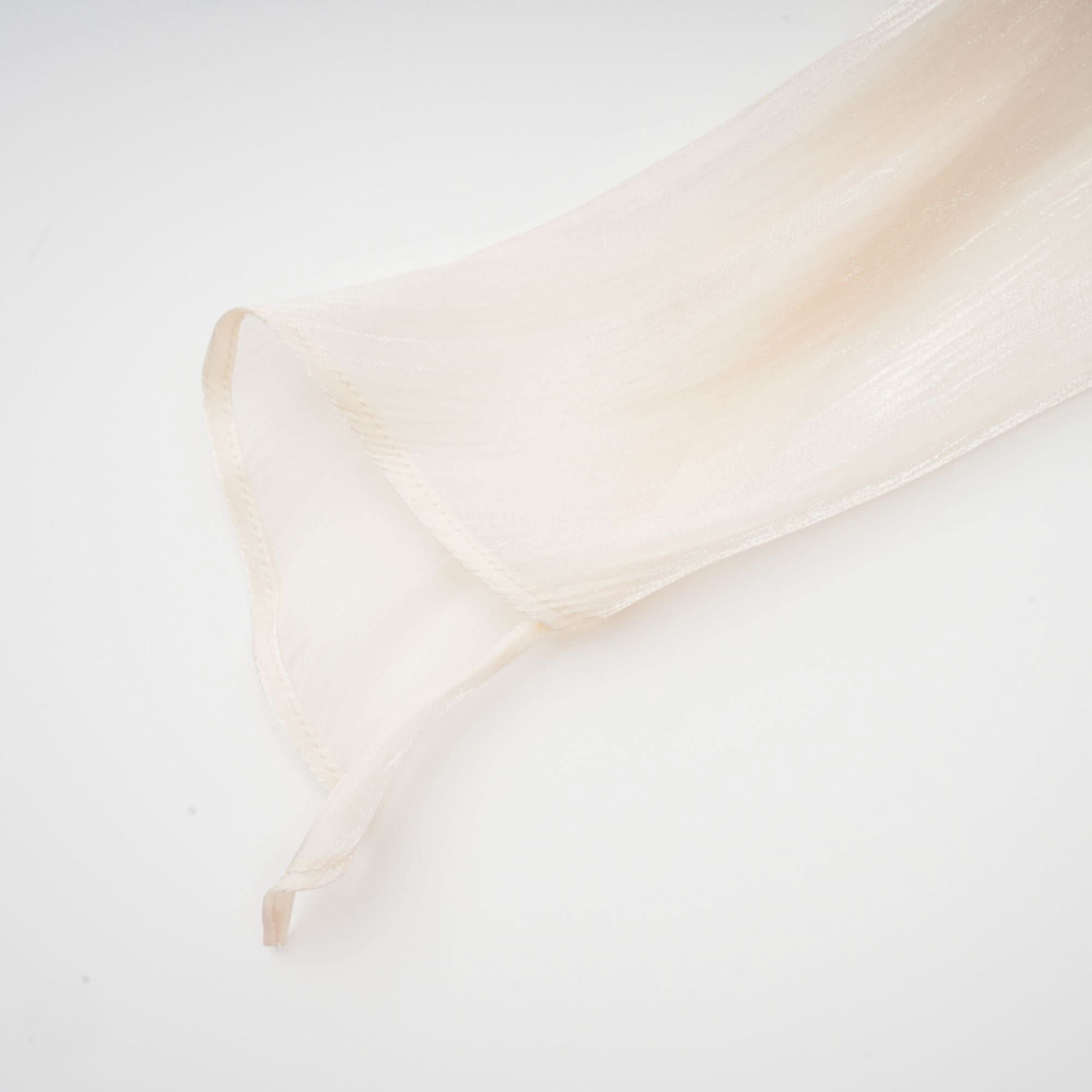 Cream ruffle fabric texture showing fine pleats and gathered construction