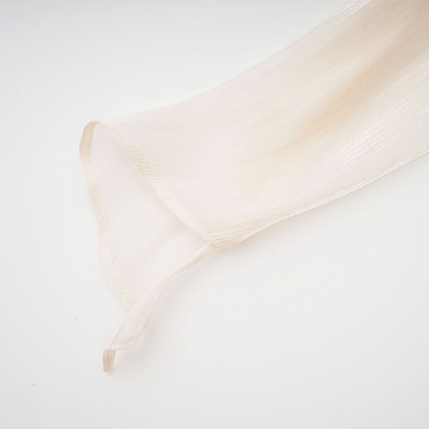 Cream ruffle fabric texture showing fine pleats and gathered construction