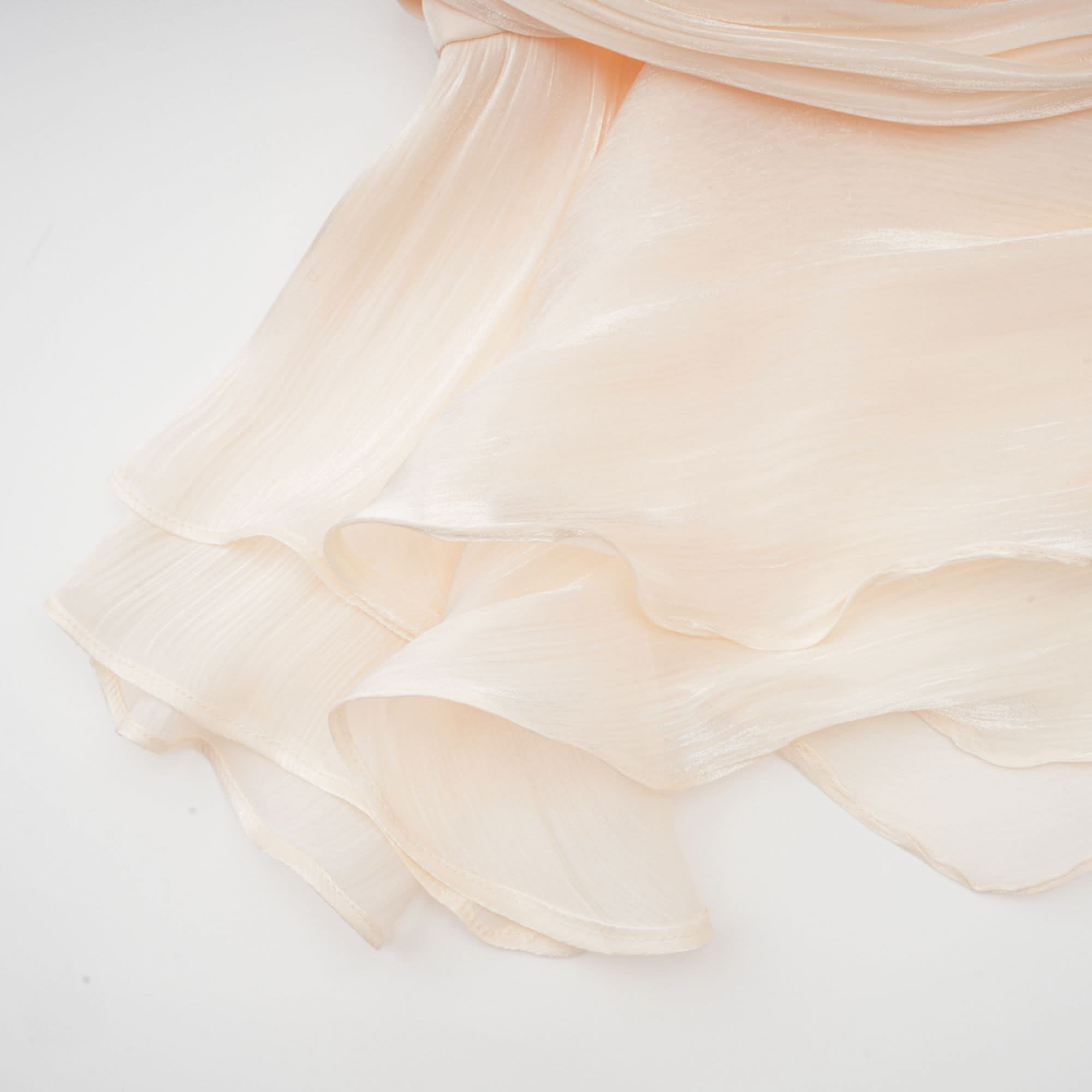 Seam detail on cream pleated ruffle dress fabric with stitching