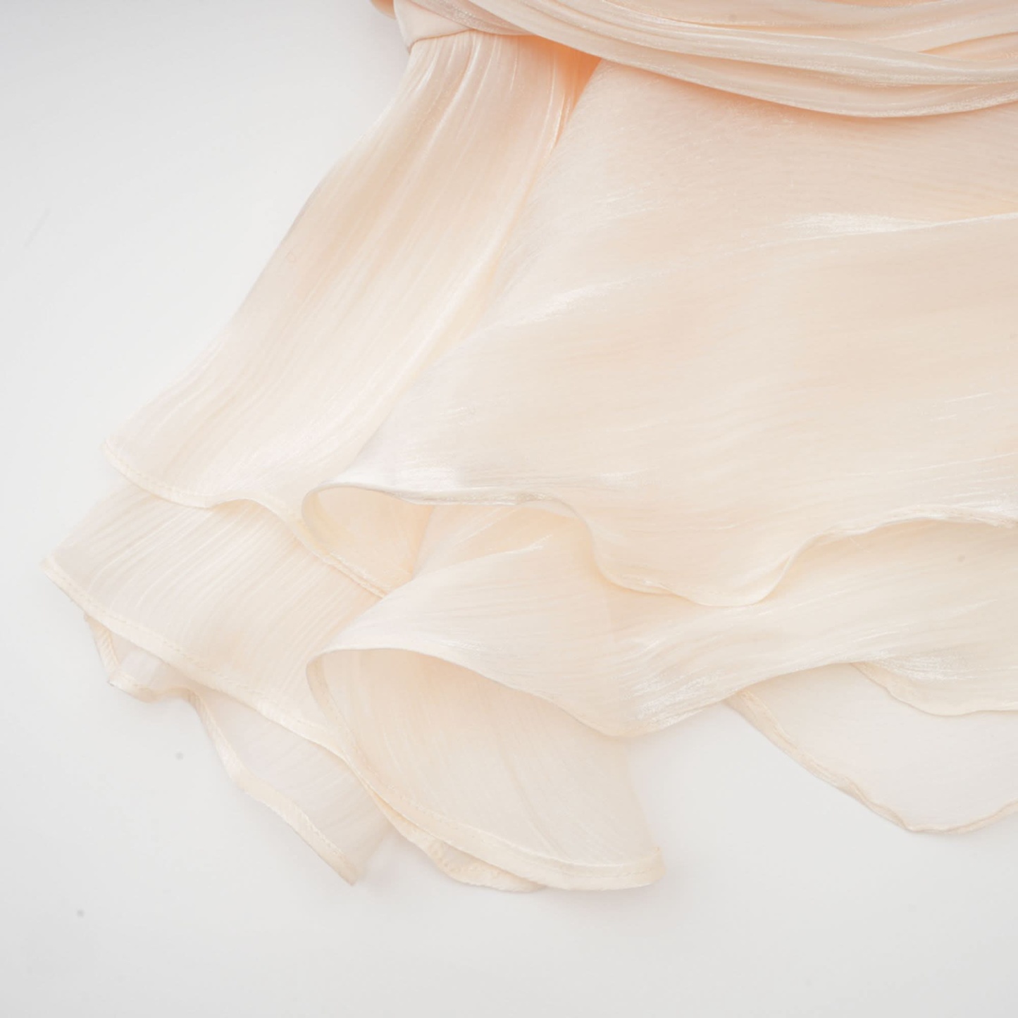 Seam detail on cream pleated ruffle dress fabric with stitching