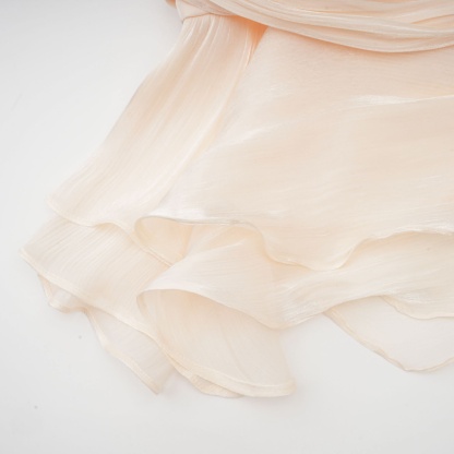 Seam detail on cream pleated ruffle dress fabric with stitching