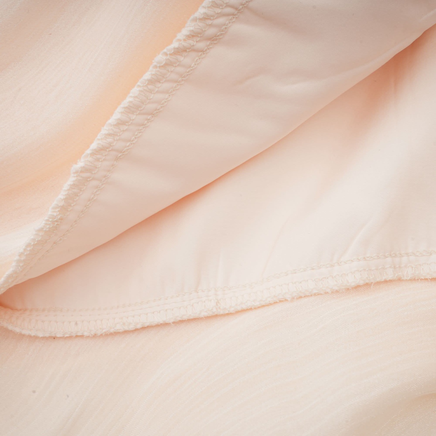 Cream ruffle mini dress hem with layered pleated fabric detail