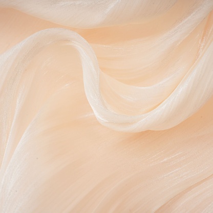 Layered ruffle edge on cream mini dress showing soft fabric drape
