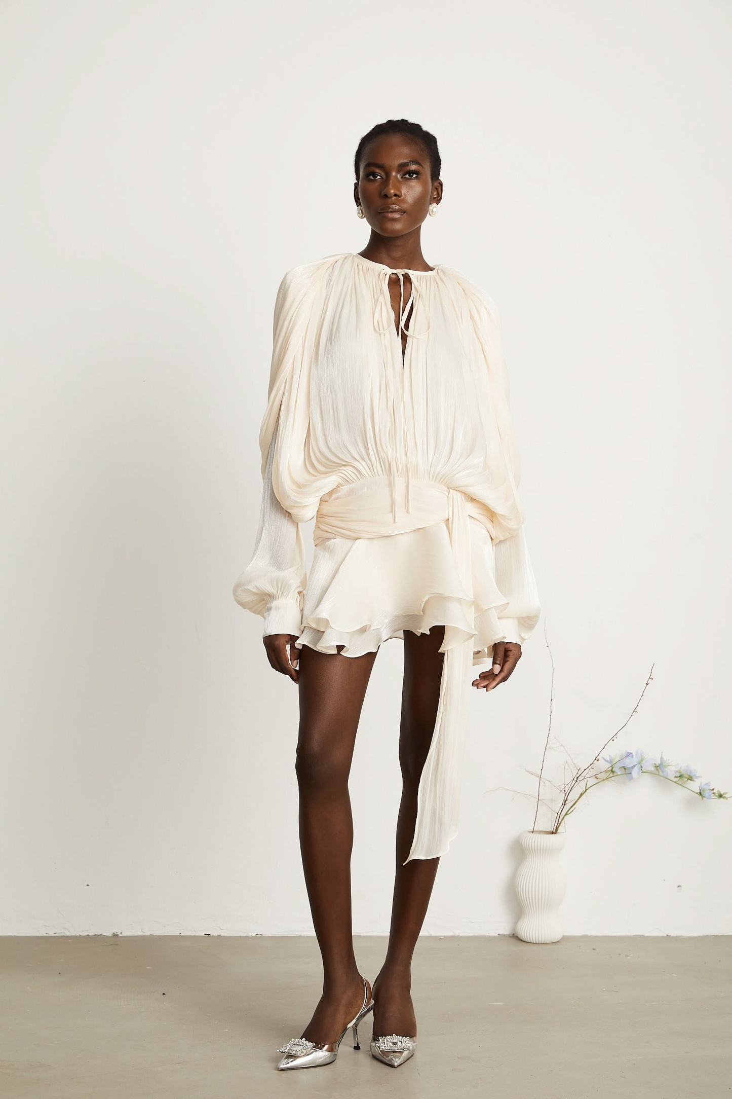 Front view of cream ruffle mini dress with billowing sleeves