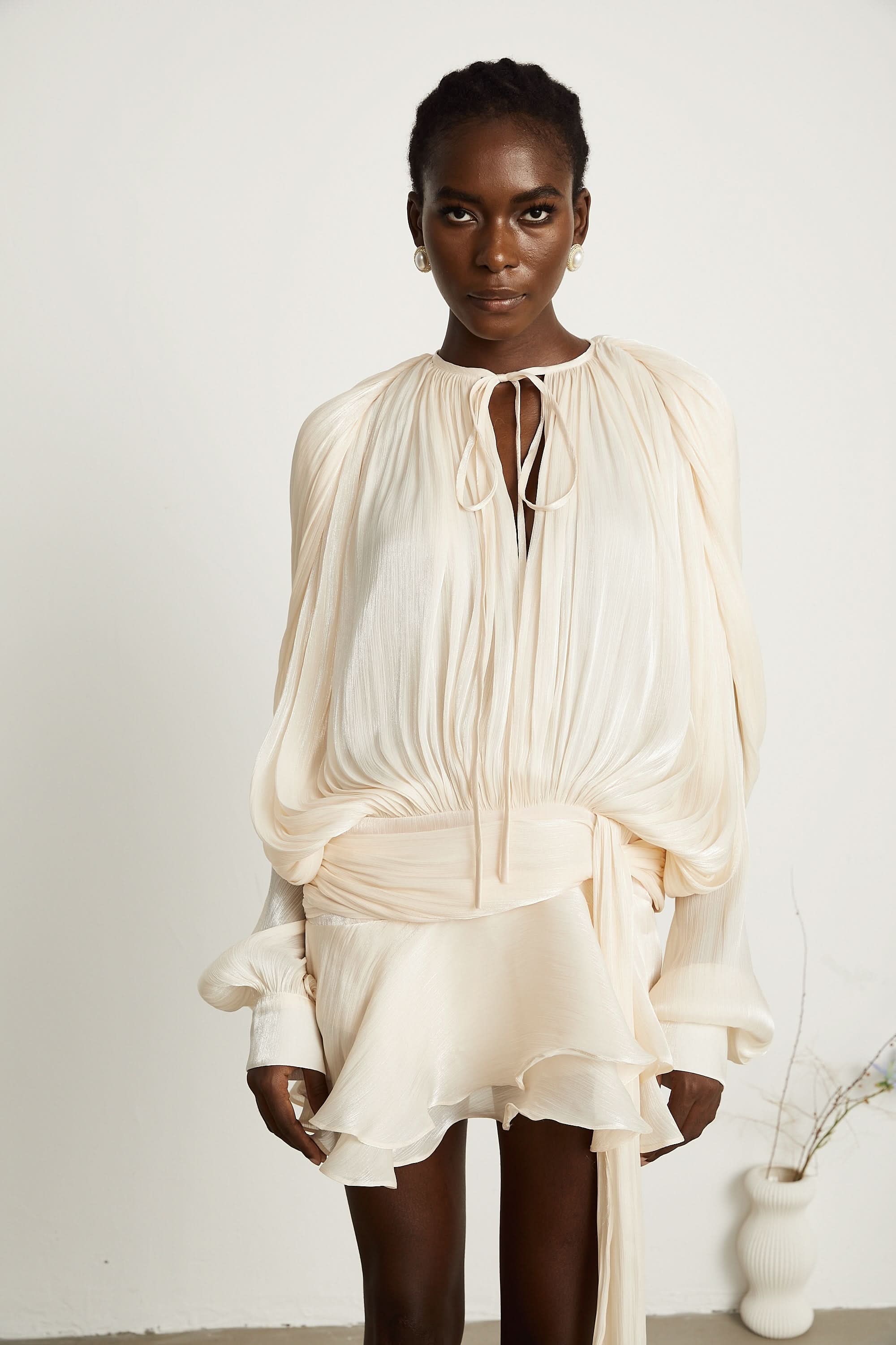 Close-up of cream mini dress neckline with tie detail