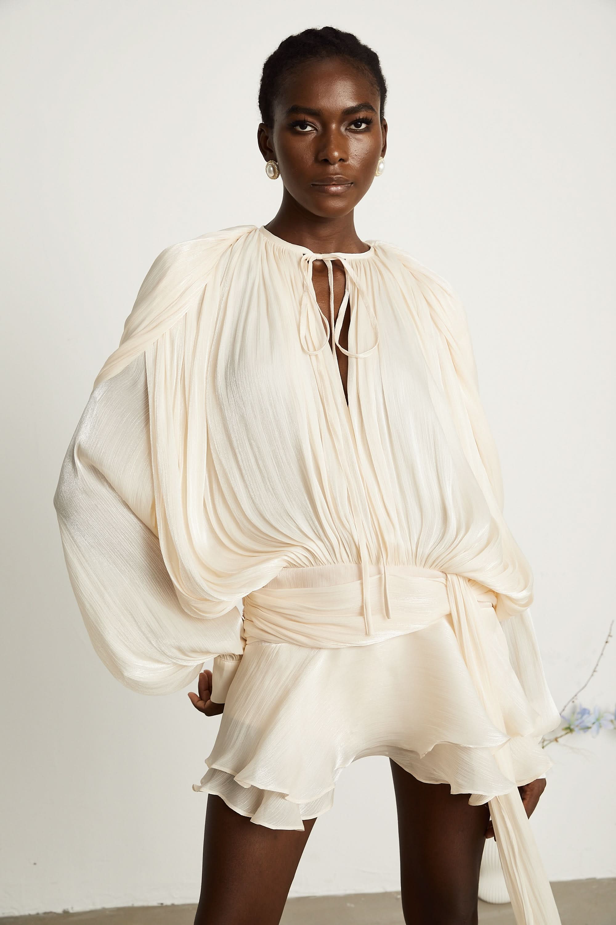 Cream pleated mini dress with voluminous cape sleeves