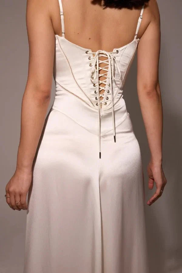 Close-up of white corset back with lace-up straps and metal eyelets detail