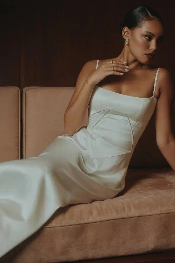 Cream corset maxi dress seated pose showing structured bodice and draped fabric
