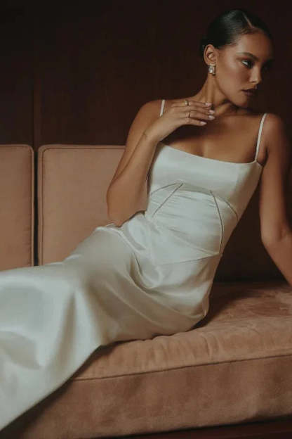 Cream corset maxi dress seated pose showing structured bodice and draped fabric