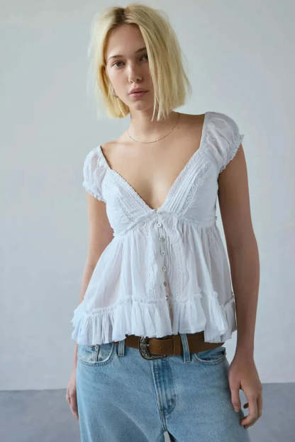 White v-neck lace top with puff cap sleeves and ruffled peplum hem detail