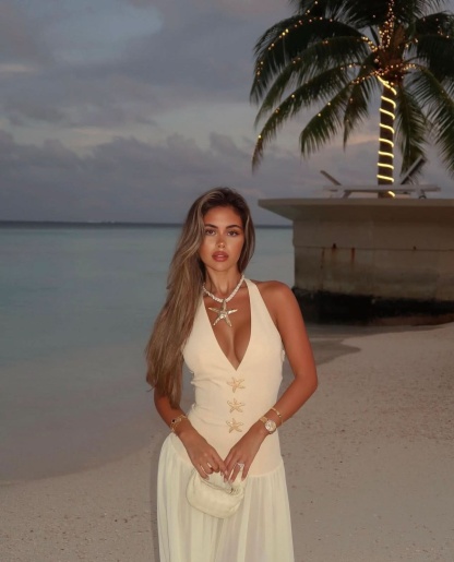 Cream halter maxi dress with starfish details on beach at sunset