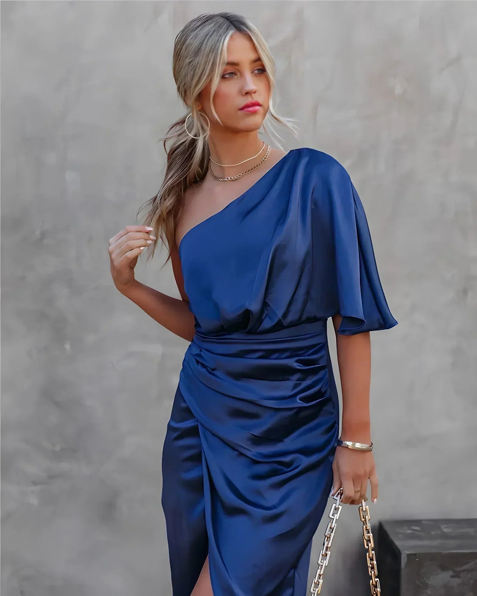 Back view of navy blue draped midi dress with flutter cape sleeve and fitted ruched bodice