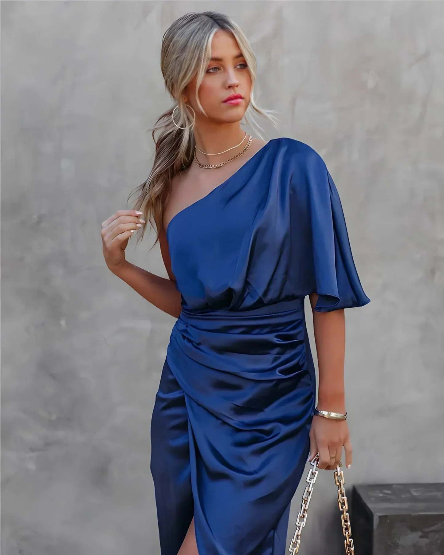 Back view of navy blue draped midi dress with flutter cape sleeve and fitted ruched bodice