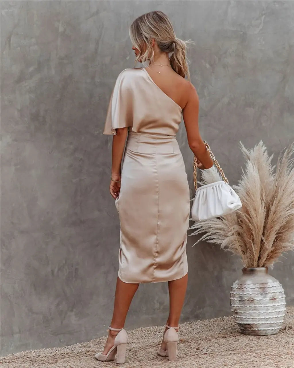 Back view of beige draped midi dress with flutter sleeve and fitted waist