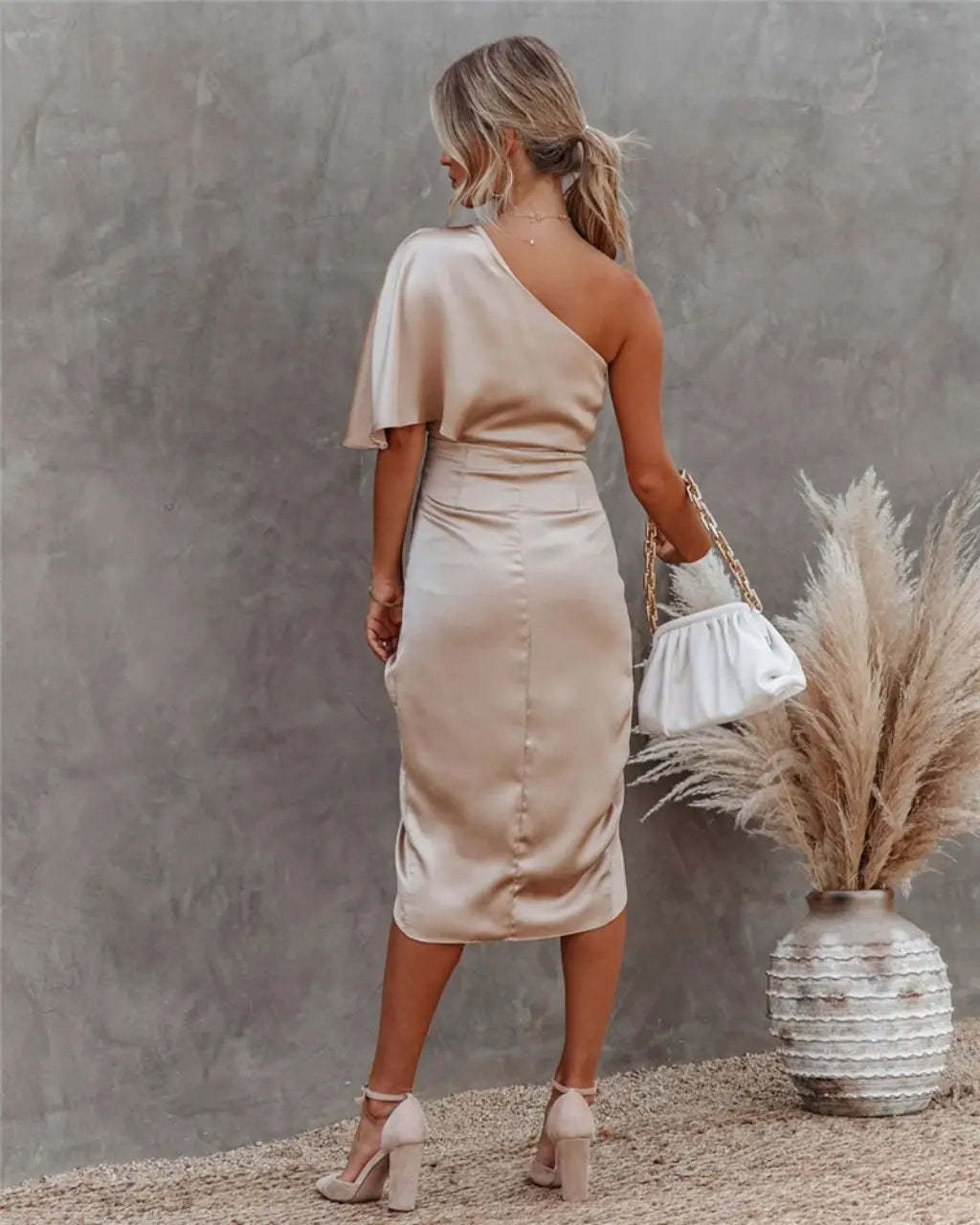 Back view of beige draped midi dress with flutter sleeve and fitted waist