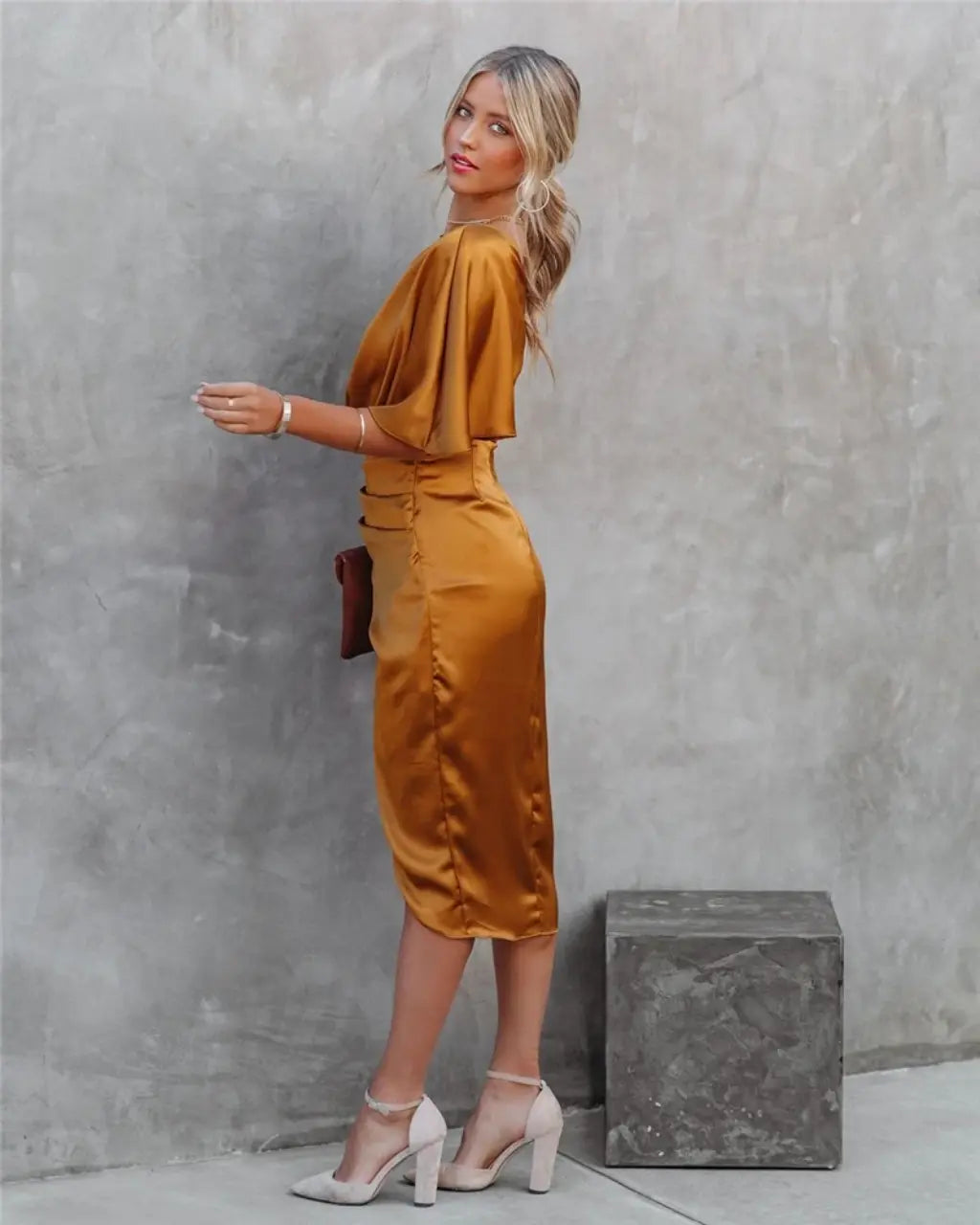 Back view of gold draped midi dress with flutter sleeve and ruched waist