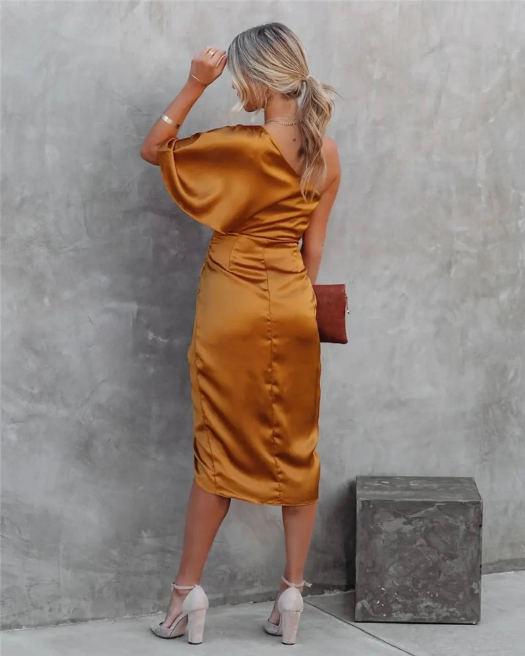 Black one-shoulder draped midi dress on street with asymmetrical neckline