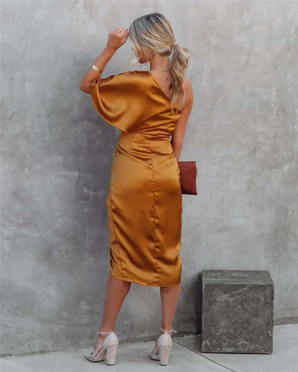 Black one-shoulder draped midi dress on street with asymmetrical neckline