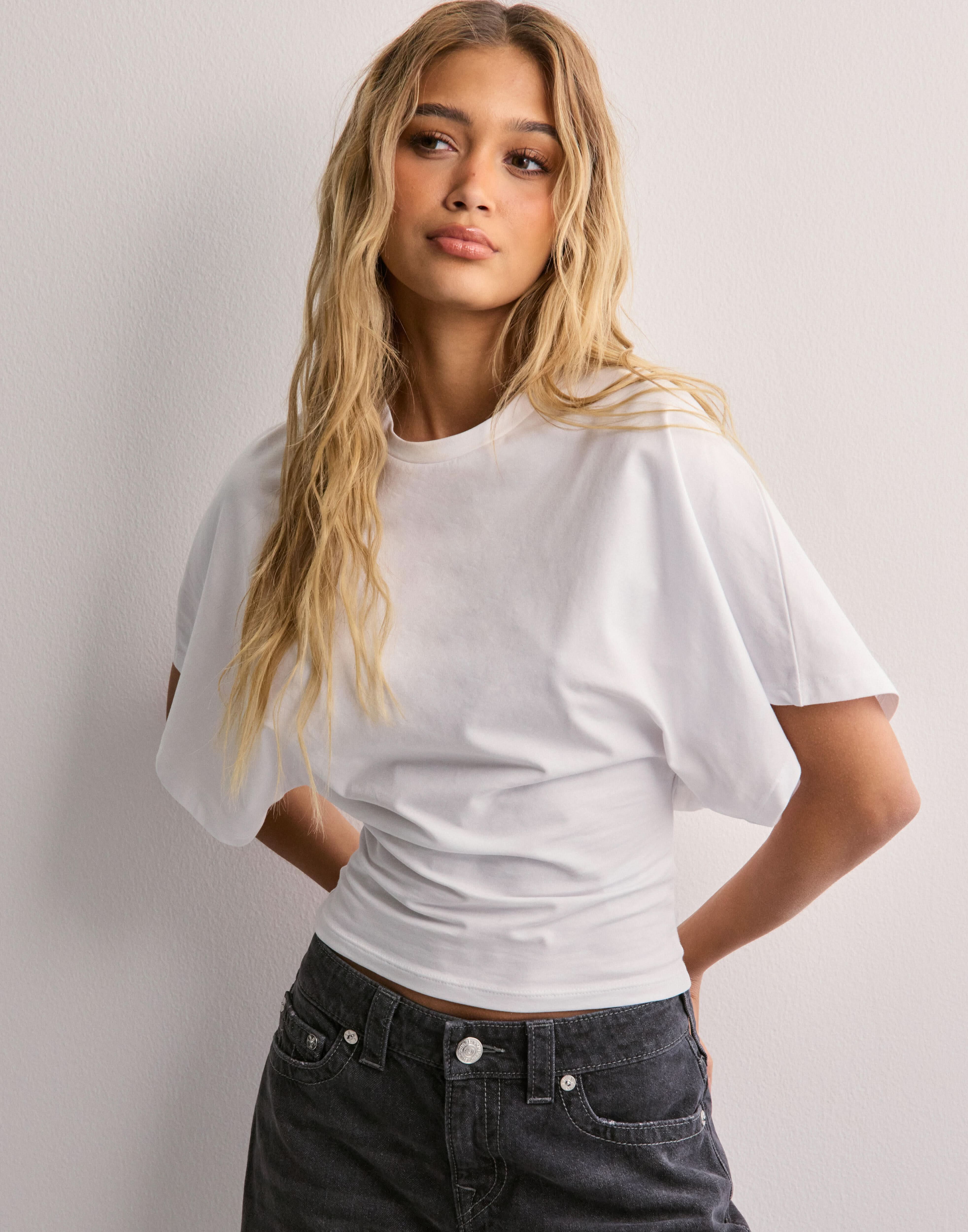Charcoal batwing crop top with wide short sleeves, side back view