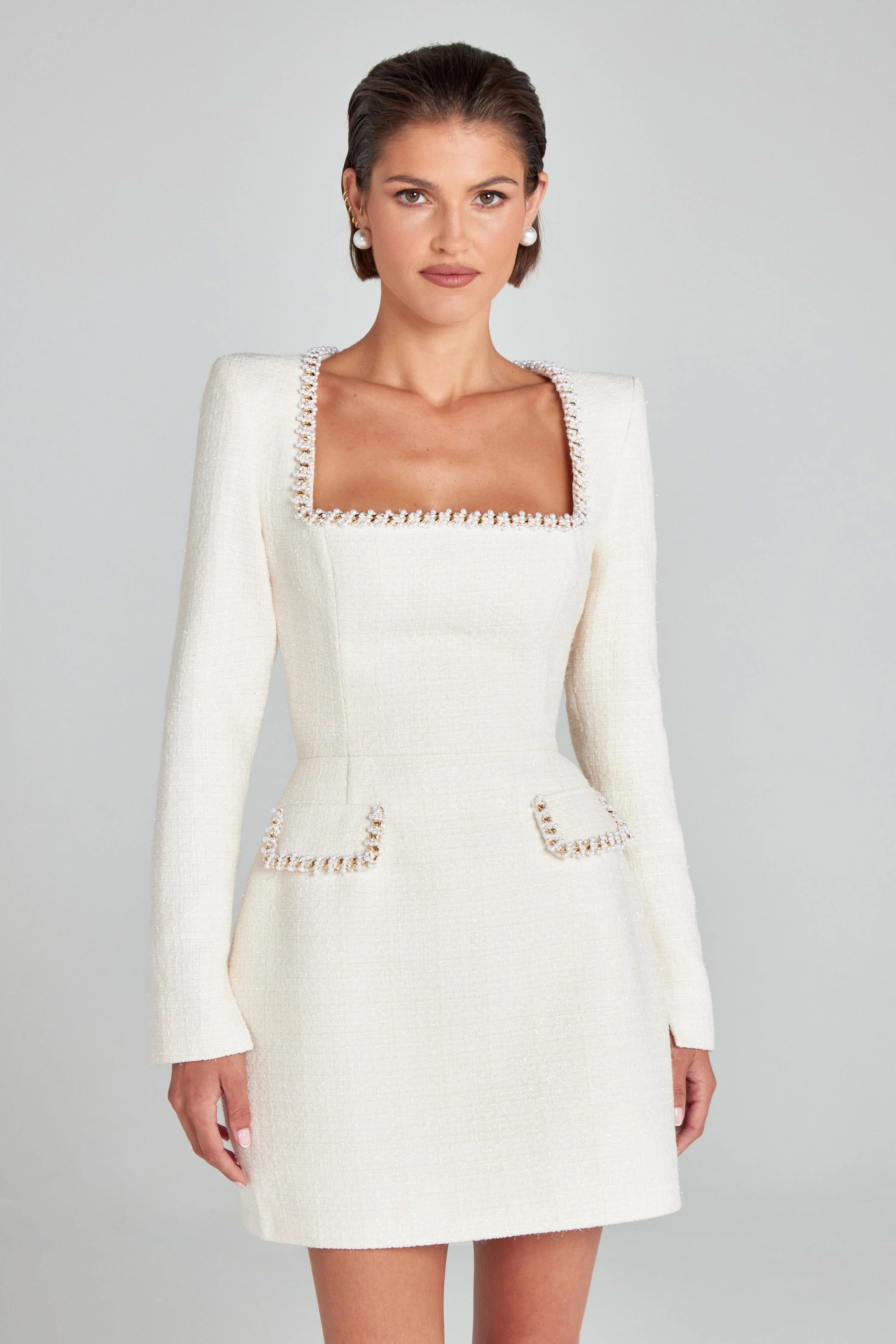 Cream tweed dress close-up showing pearl-trimmed square neckline