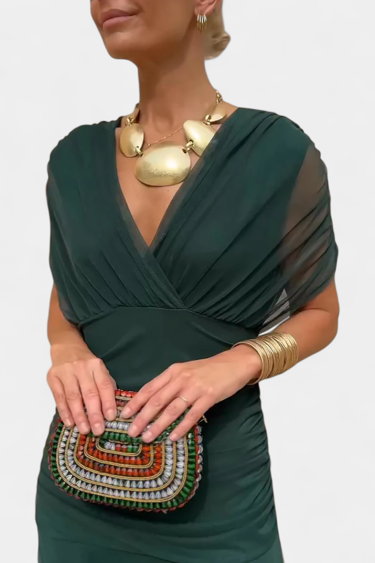 Forest green ruched maxi dress with off-shoulder wrap and gold statement necklace
