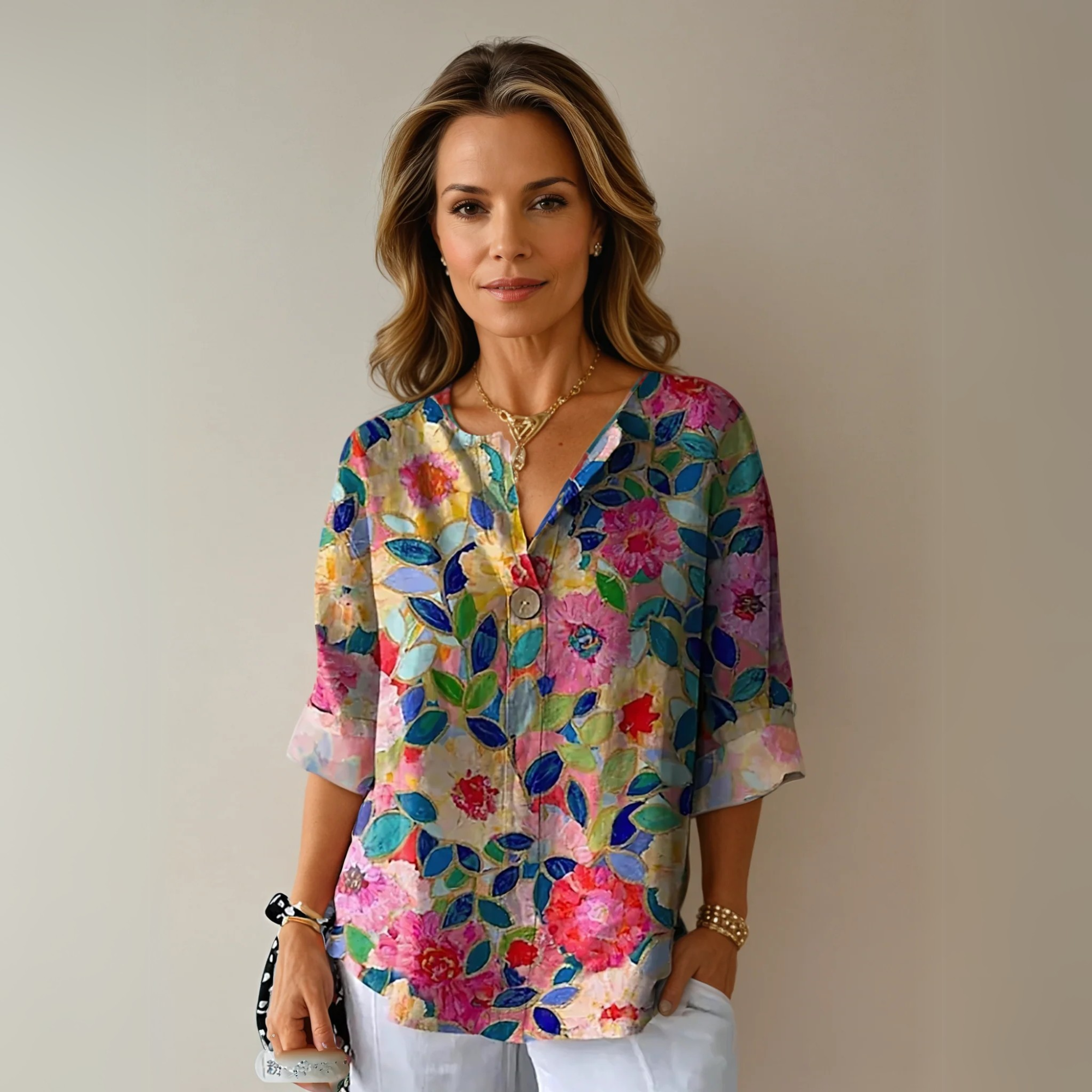 Multicolor floral 3/4 sleeve top with pink, red, yellow and blue blooms on neutral background
