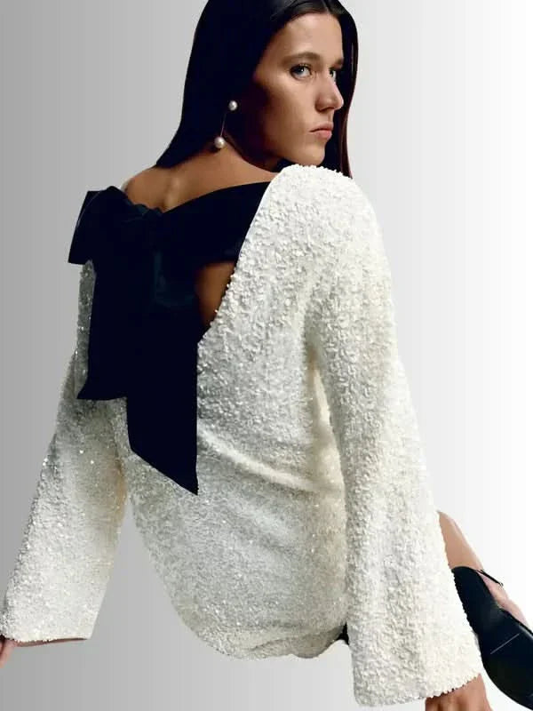 Cream textured dress with black bow back detail side angle