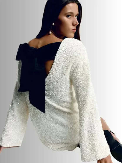 Cream textured dress with black bow back detail side angle
