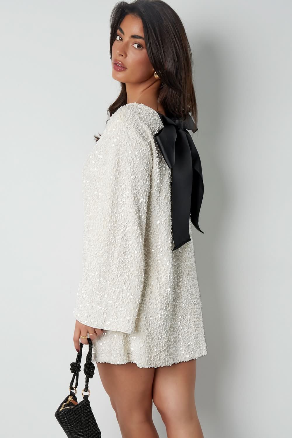 Cream mini dress with black bow accent side profile view